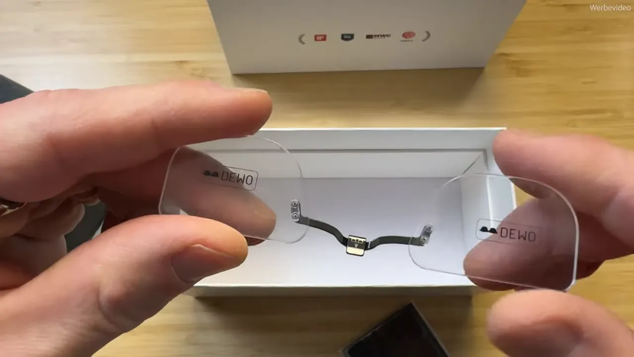 Zwei transparente Demo-Gläser mit Mittelteiler/Adapter, vor einer offenen Verpackung