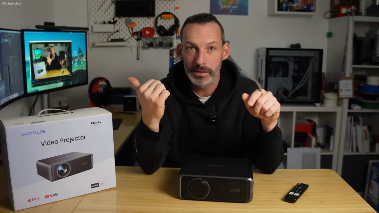 Moderator am Tisch mit iWIMIUS P65 Projektor und Verpackung, Frontansicht