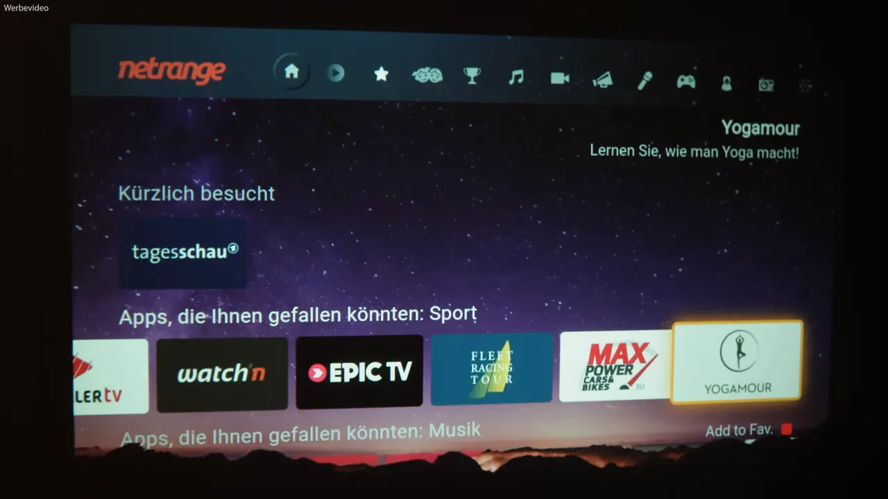 Projizierte App‑Übersicht des iWIMIUS P65 mit hervorgehobener 'YOGAMOUR' Kachel, scharf und gut lesbar