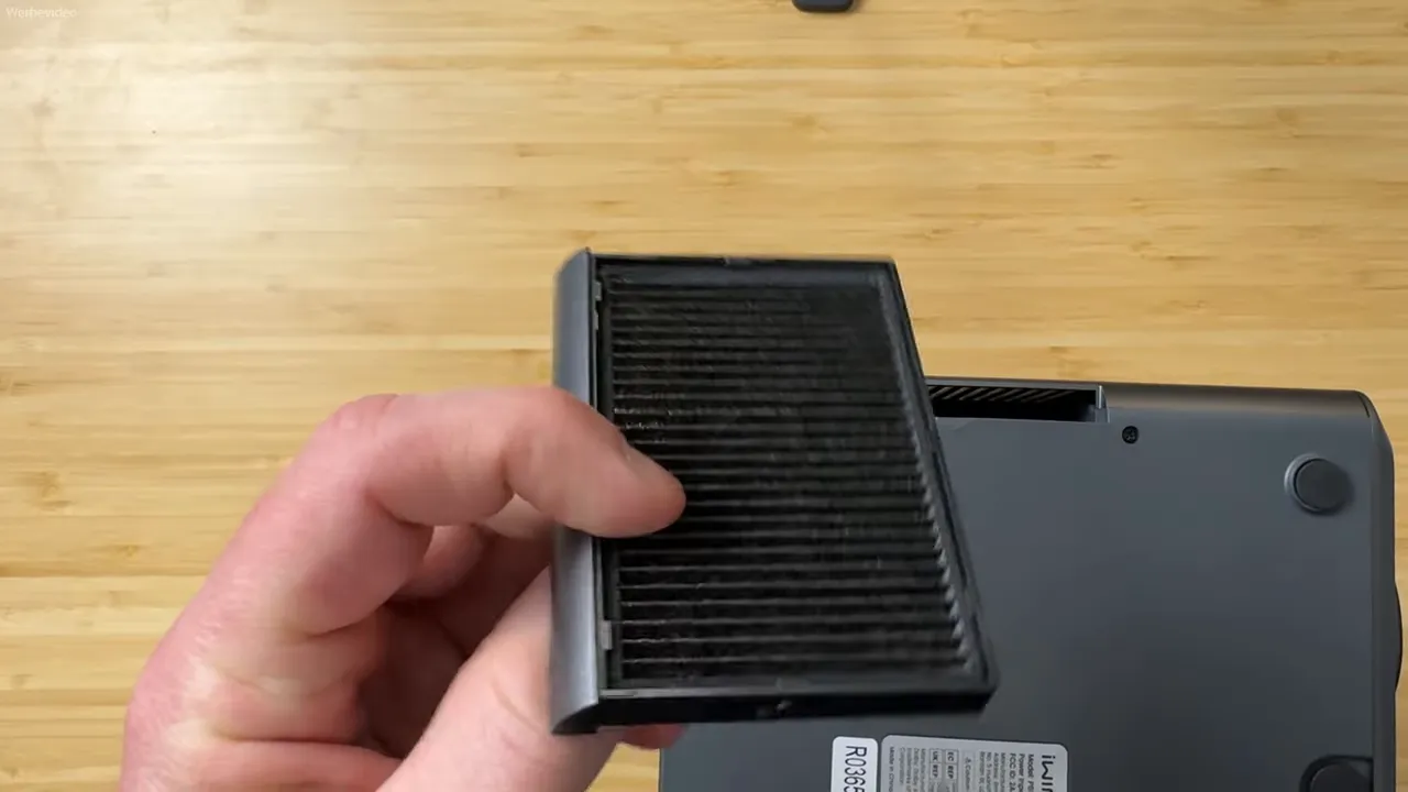 Hand hält herausgenommenen Lüfterfilter des iWIMIUS P65