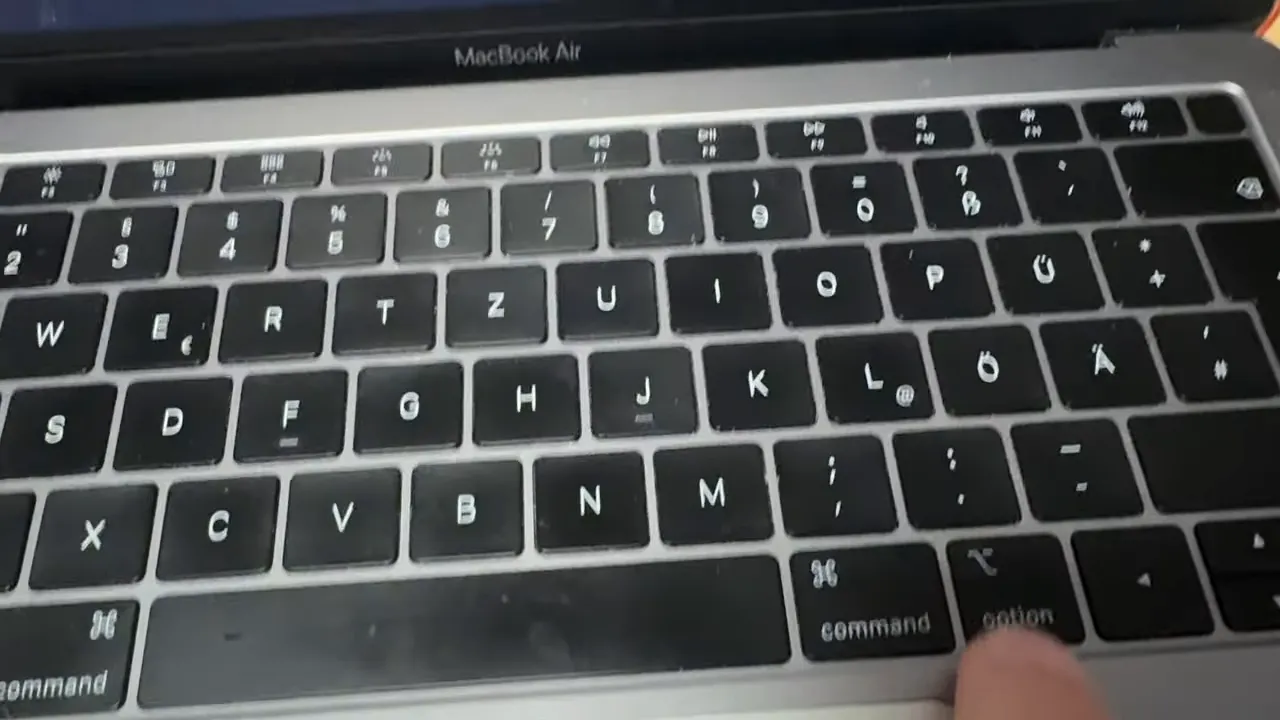Finger drückt die Option (Alt) Taste auf einem MacBook Air Keyboard